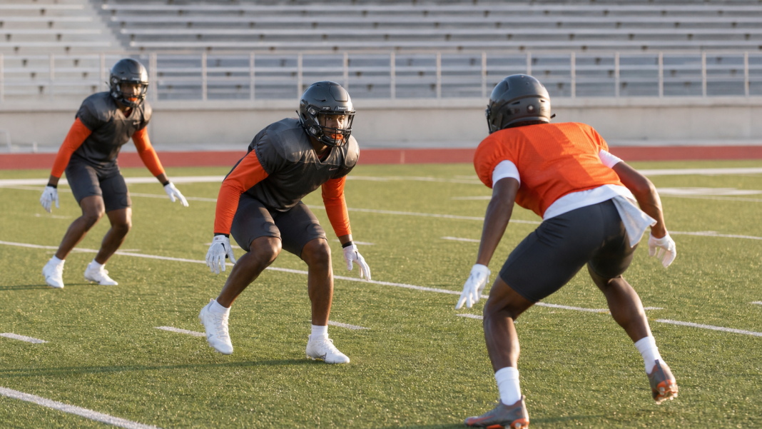 College defensive backs practice under stadium lights in South Texas
